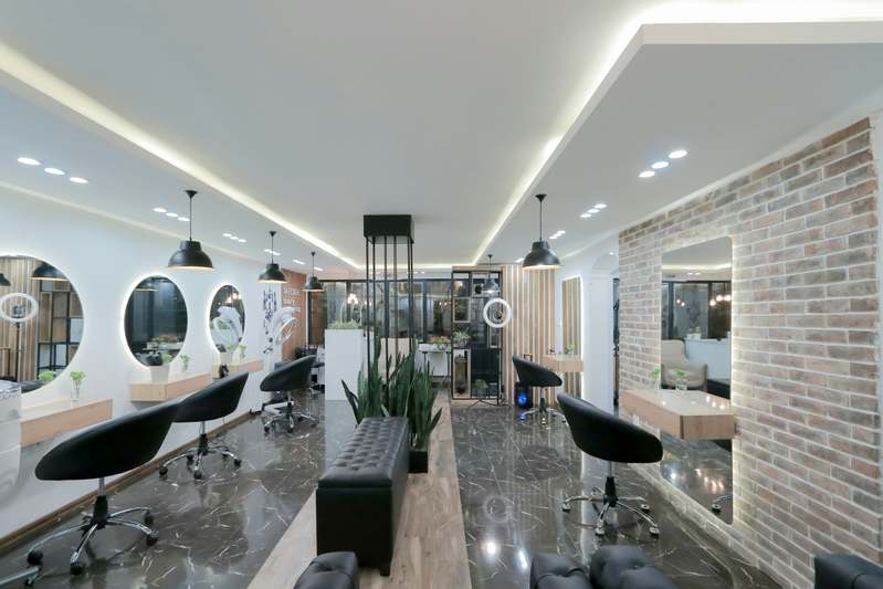 Female esthetician holding glycolic acid products in a clean, well-lit skincare studio